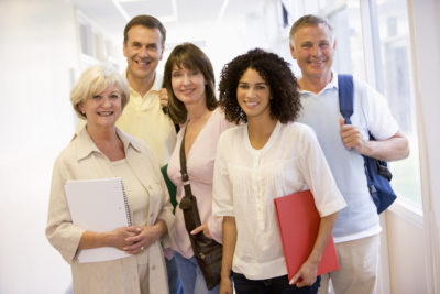 Group of men and women stood smiling in a work setting