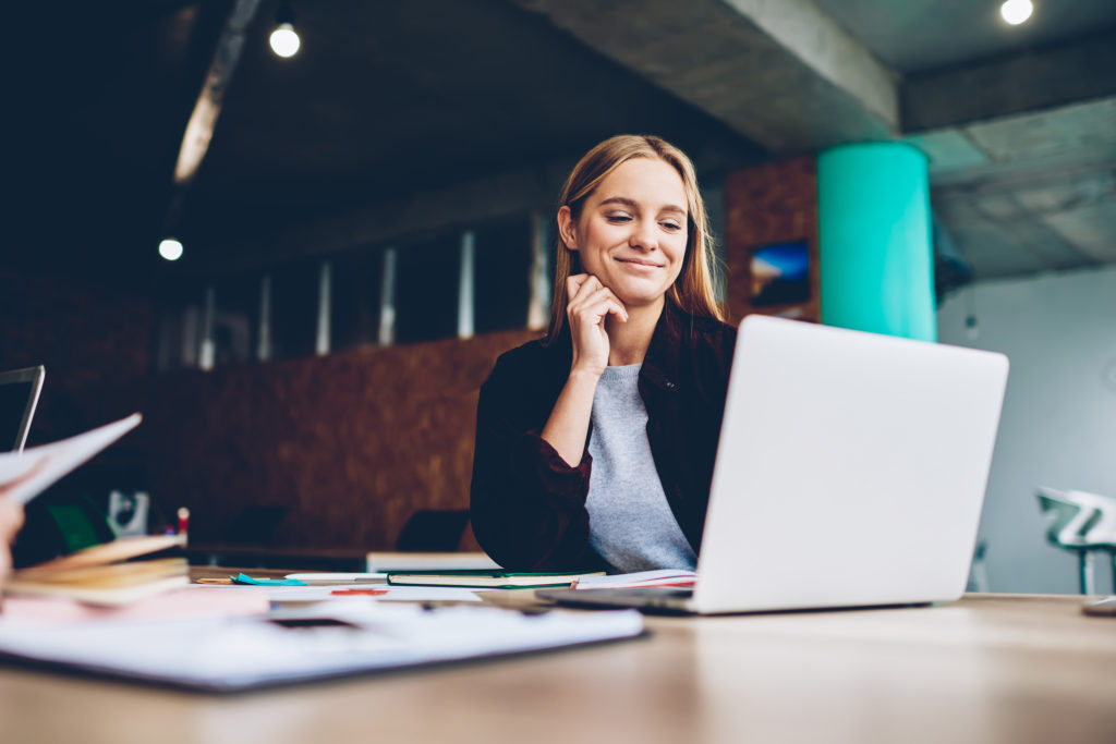 Business woman smiles at a laptop screen