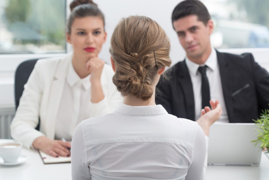 A man and woman interview a woman for a position