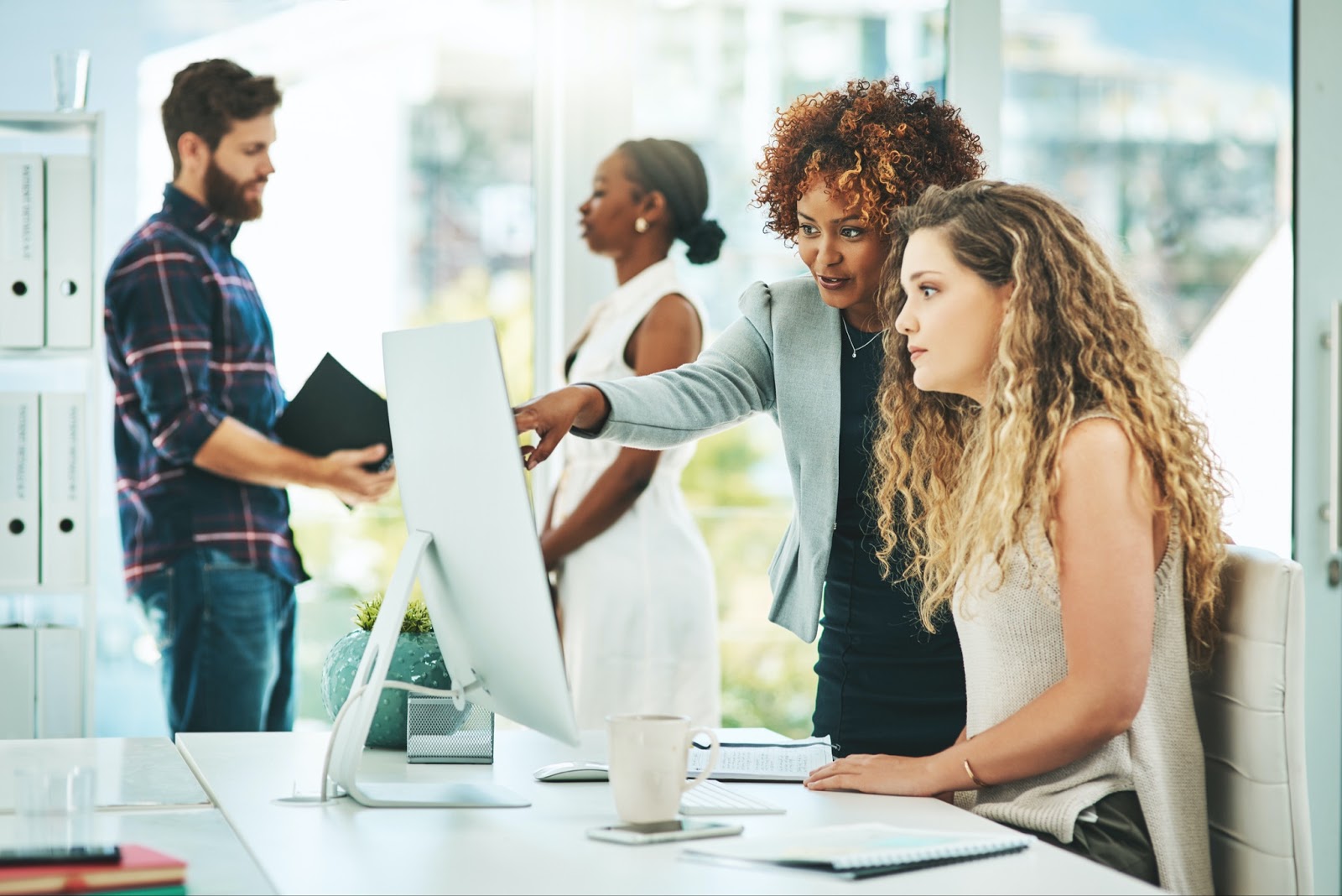 a woman having a discussion with another woman in an office environment