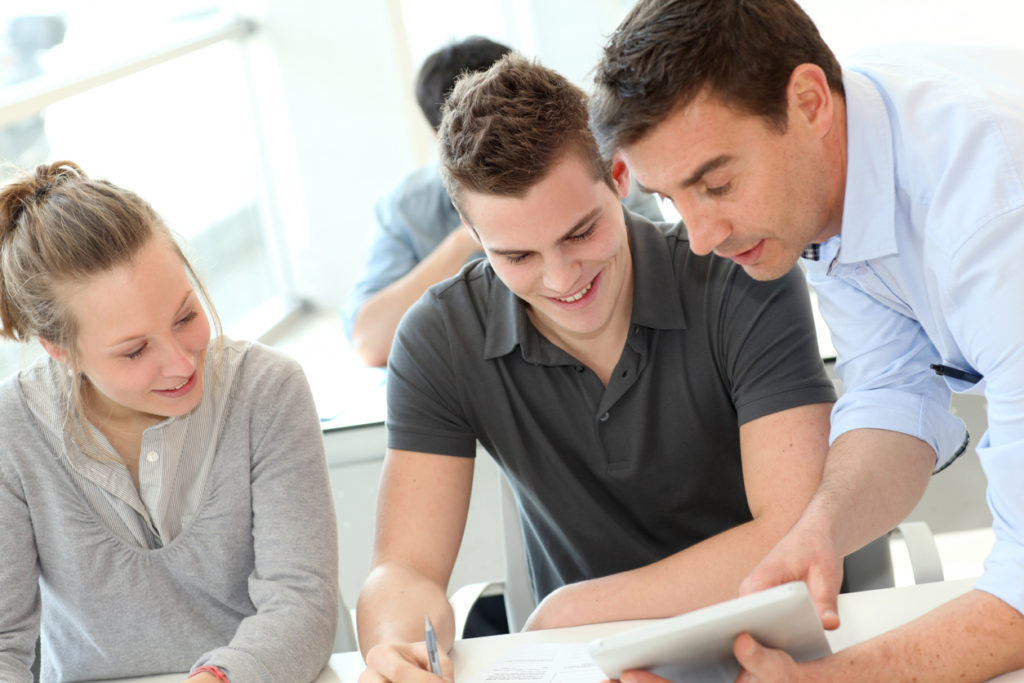 Instructor helping apprentices in a classroom setting