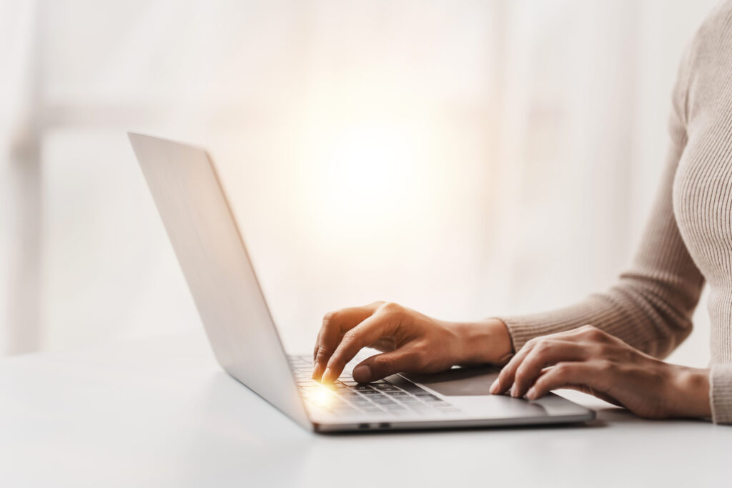 a women typing on a laptop.