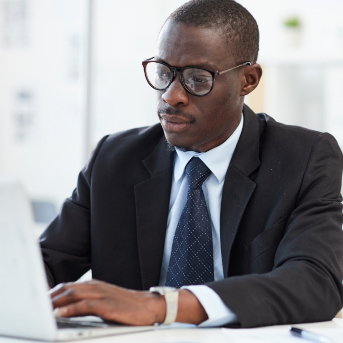 Man wearing glasses using a laptop